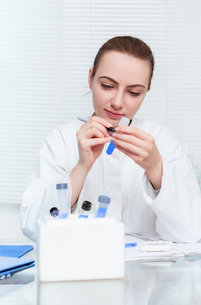 Portrait of a young scientis labeling tube for experiment