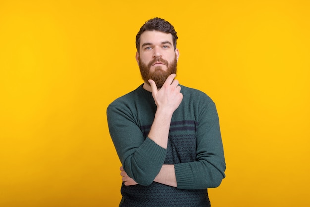 Portrait of a young serious bearded man looking at the camera