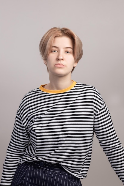 Photo portrait of a young serious girl in a striped longsleeve