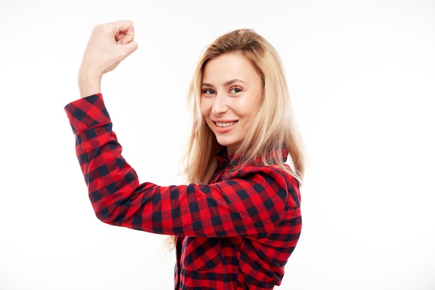 Portrait of young sexy blond woman showing biceps demonstrating girl power isolated on white background