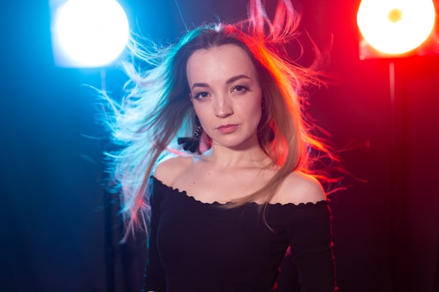 Portrait of young sexy woman with flashes on background.