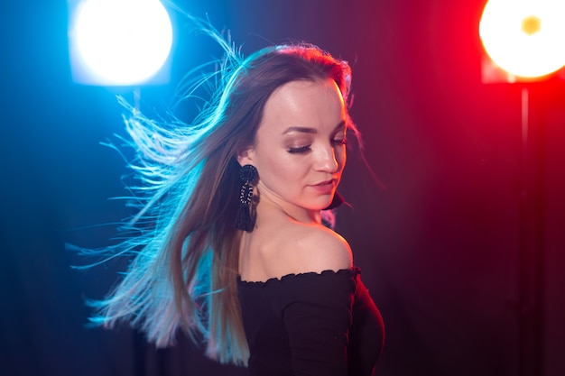 Portrait of young sexy woman with flashes on wall.