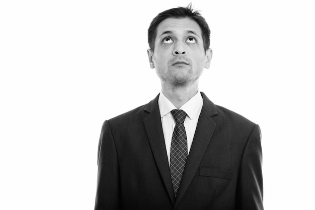 Portrait of young skinny businessman wearing suit isolated on white in black and white