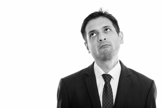 Portrait of young skinny businessman wearing suit isolated on white in black and white