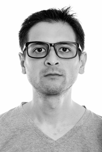 Portrait of young skinny nerd man wearing eyeglasses isolated on white in black and white