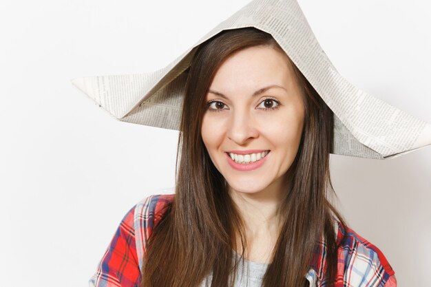 Ritratto di giovane bella donna sorridente in cappello del giornale isolato su fondo bianco. accessori per ristrutturazione appartamento camera. riparare il concetto di casa. copia spazio per la pubblicità.