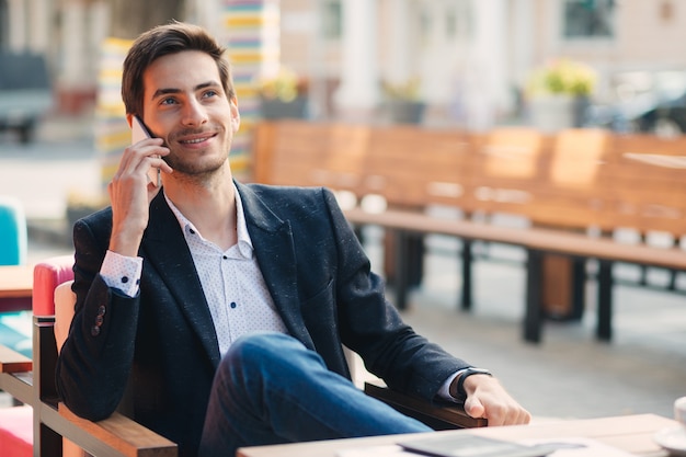 Portrait of young smiling businessman talking on the phone