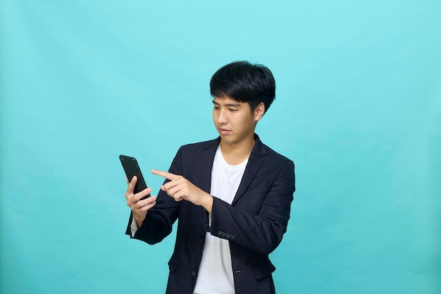 Portrait of a Young smiling handsome Asian man in a semiformal suit using a mobile phone