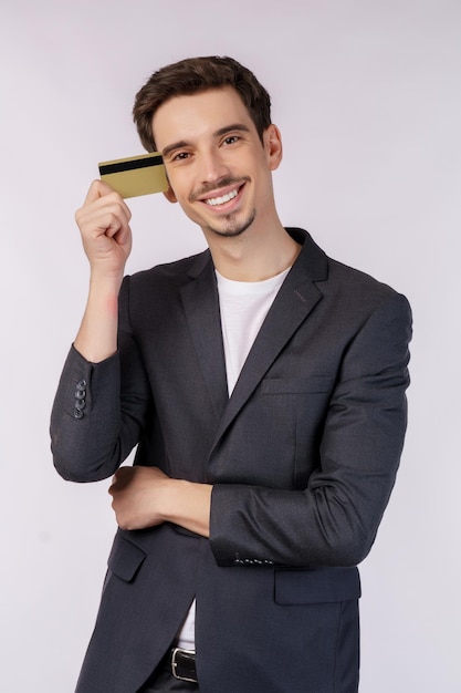 Portrait of Young smiling handsome businessman showing credit card isolated over white background