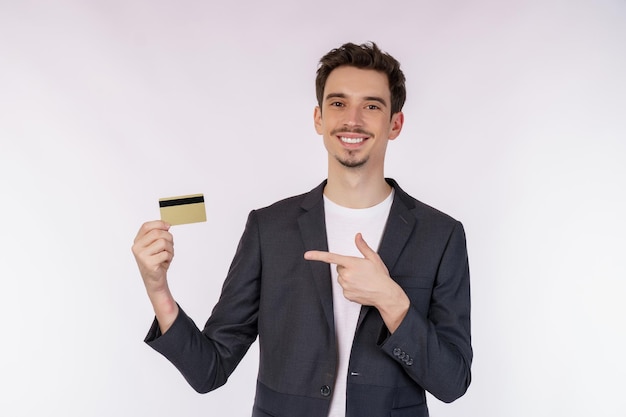 Photo portrait of young smiling handsome businessman showing credit card isolated over white background