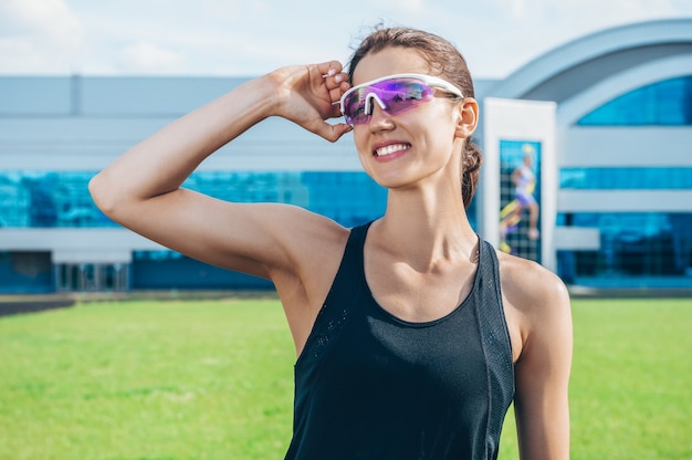 Portrait of a young smiling runner posing at a football stadium. Sports concept.