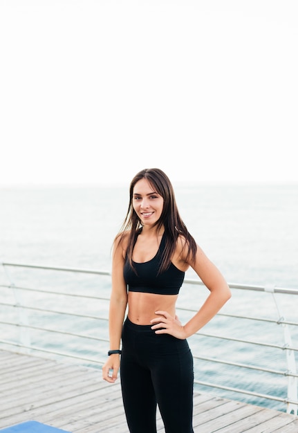 Portrait of a young smiling sports woman in sports clothes on the bech