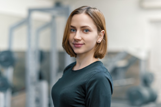 Portrait of young smiling woman in the gym