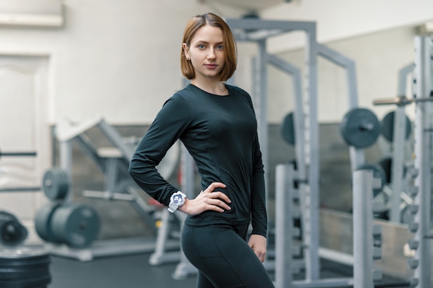 Portrait of young smiling woman in the gym