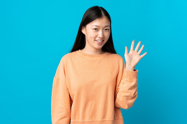 Portrait of a young smiling woman saluting