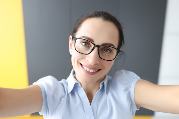 Portrait of young smiling woman taking selfie