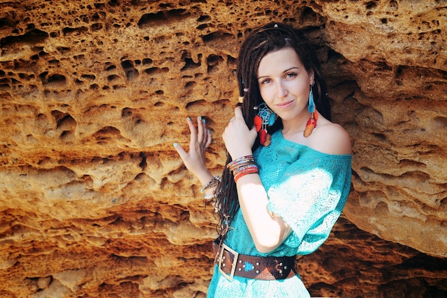 Portrait of a young smiling woman wearing dreadlocks hairstyle dressed in blue lace dress