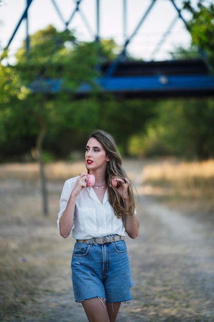 ハイライトされた髪と公園でポーズをとるヘッドフォンを持つ若いスペイン人女性のポートレート