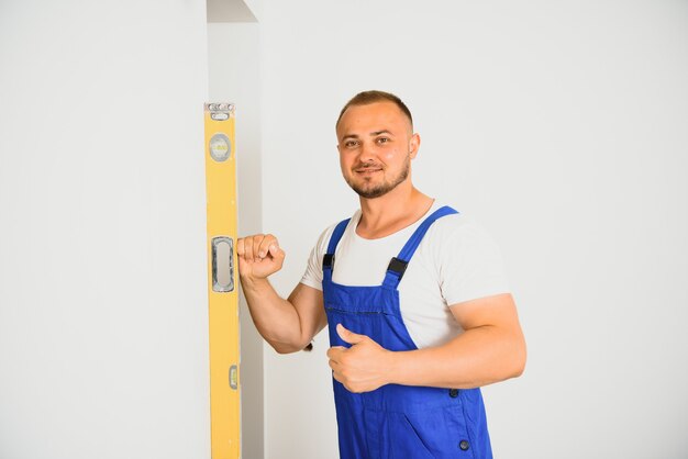 Portrait of young specialist making wall plane in new building