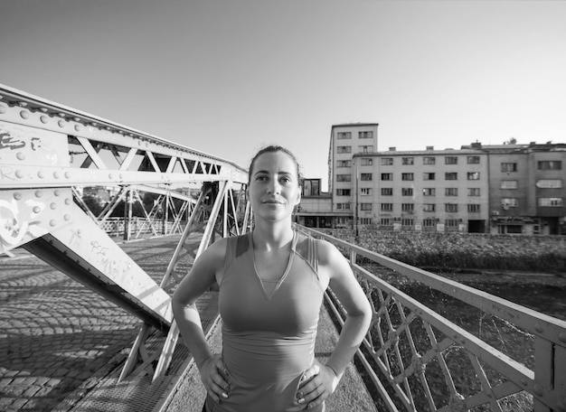 portrait of a young sporty jogging woman at sunny morning in the city