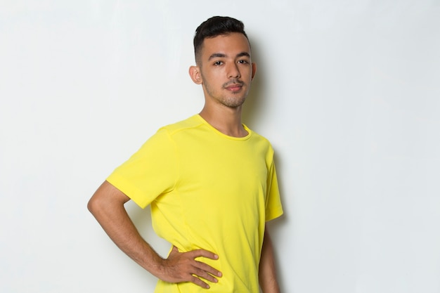 portrait young sporty man dressed in yellow tshirt on white background