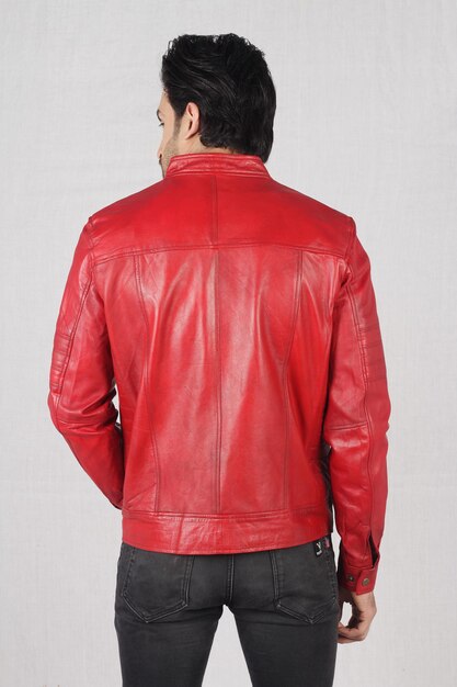 Photo portrait of a young stylish man in red leather jacket and black jeans with white background