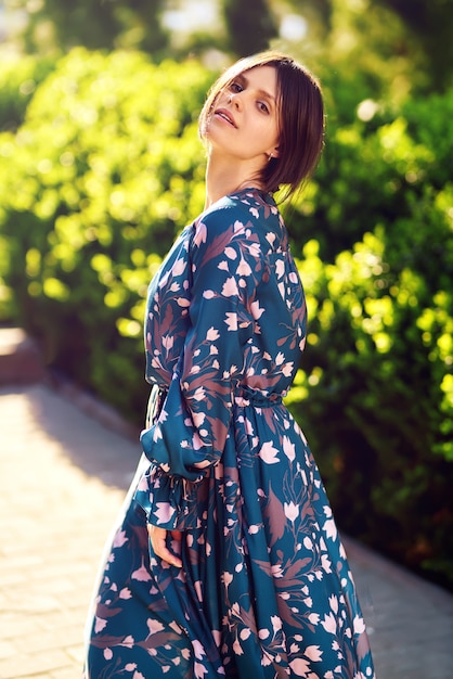 The portrait of young stylish woman in fashion dress posing at sunset in the city. Lifestyle concept.