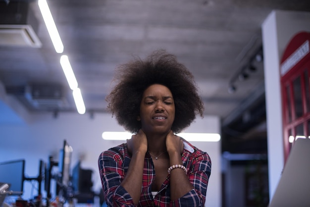 portrait of a young successful African American beautiful woman who enjoys spending a quality and joyful time while working in a large modern office