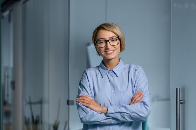 職場の女性労働者と一緒に立ってオフィス内の若い成功したビジネスウーマンの肖像画