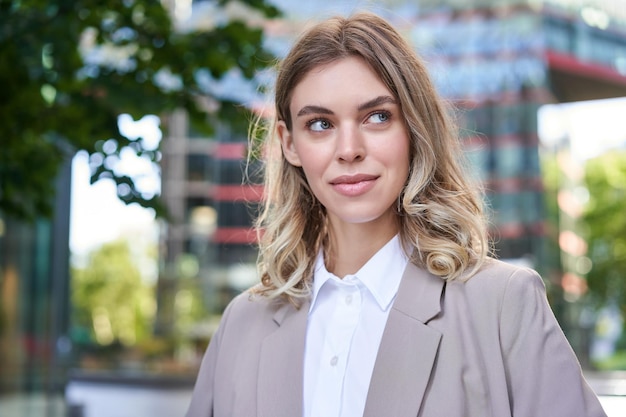 Portrait of young successful businesswoman in suit cross arms on chest smile and look confident stan