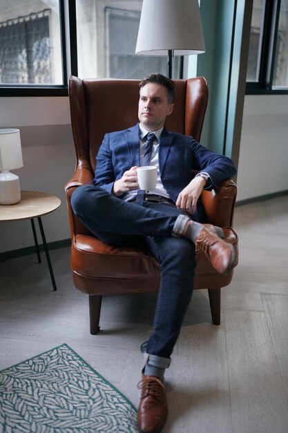 Portrait of young successful confident businessman in the\
modern office building businessman