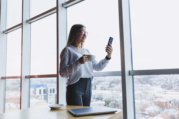 Portrait of a young and successful woman solving business problems during a telephone conversation sitting in a modern cafe Cute interior is enjoying his free time in the cafe