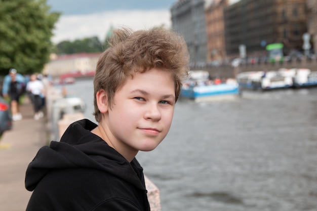 portrait of a young teenager boy on city background