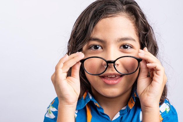 Photo portrait of a young teenager putting glasses on her face and looking at the camera