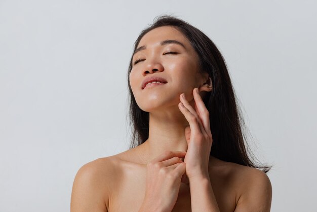 Portrait of young tender woman posing isolated over gray studio background