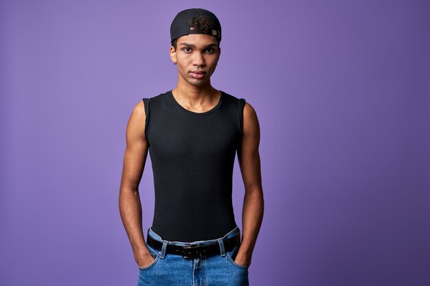 Portrait young transgender brunette man in black tshirt cap blue jeans hispanic trans gender male