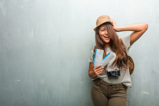 Photo portrait of young traveler latin woman against a wall frustrated and desperate