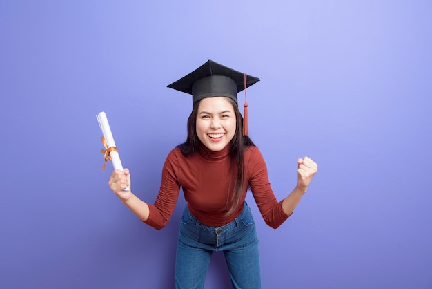Ritratto di giovane donna studente universitario con cappello di laurea