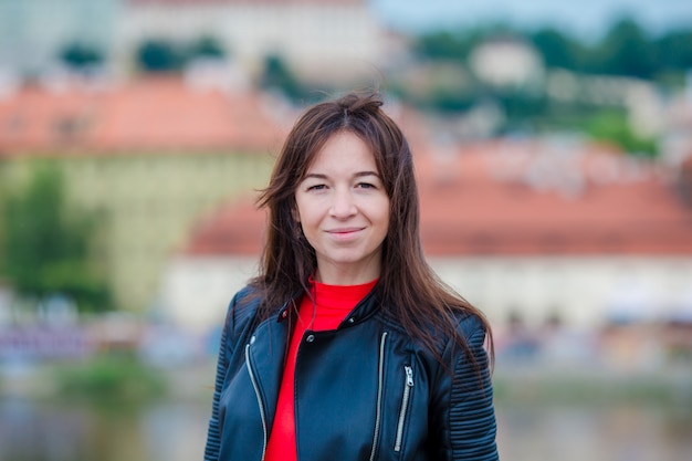 Portrait of young urban woman in european city on the famous bridge. Warm summer early morning in Prague, Czech Republic