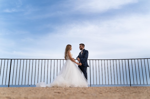 海と空を背景に若い結婚式のカップルの肖像画