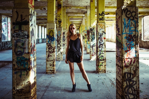 portrait of young woman in abandoned graffitied buidling