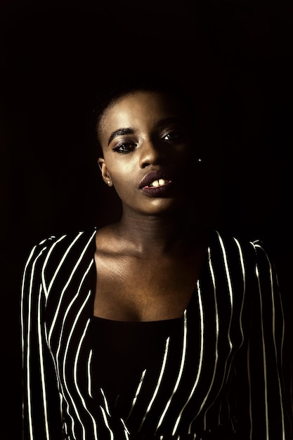 Photo portrait of young woman against black background