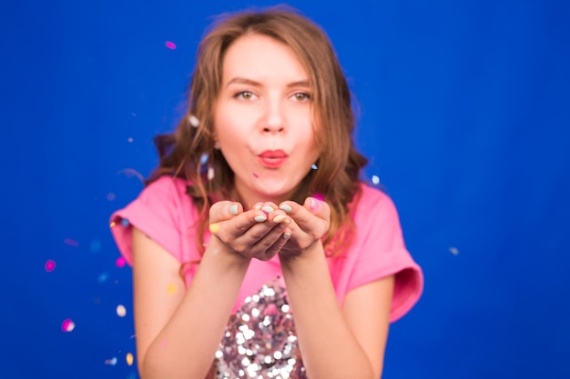 Portrait of young woman against blue background