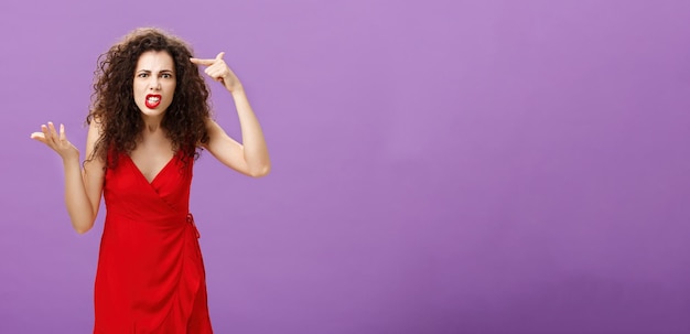 Portrait of young woman against blue background