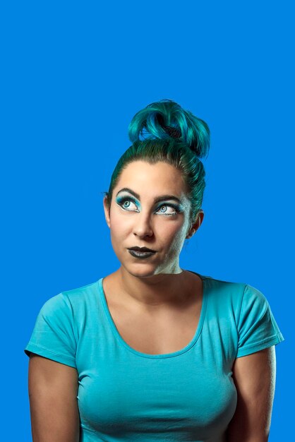 Portrait of young woman against blue background