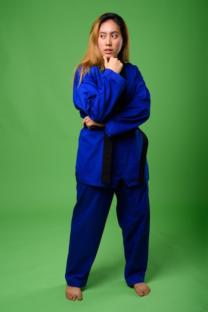 Portrait of young woman against blue background