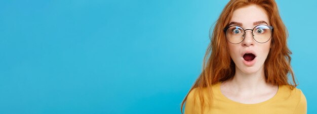 Portrait of young woman against blue background