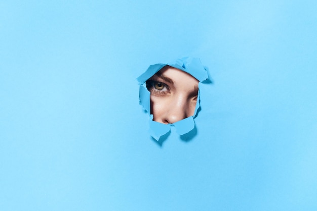 Portrait of young woman against blue background