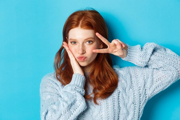 Portrait of young woman against blue background