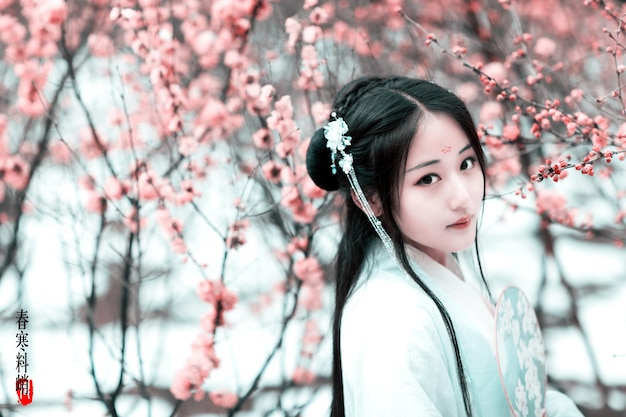 Portrait of young woman against cherry tree